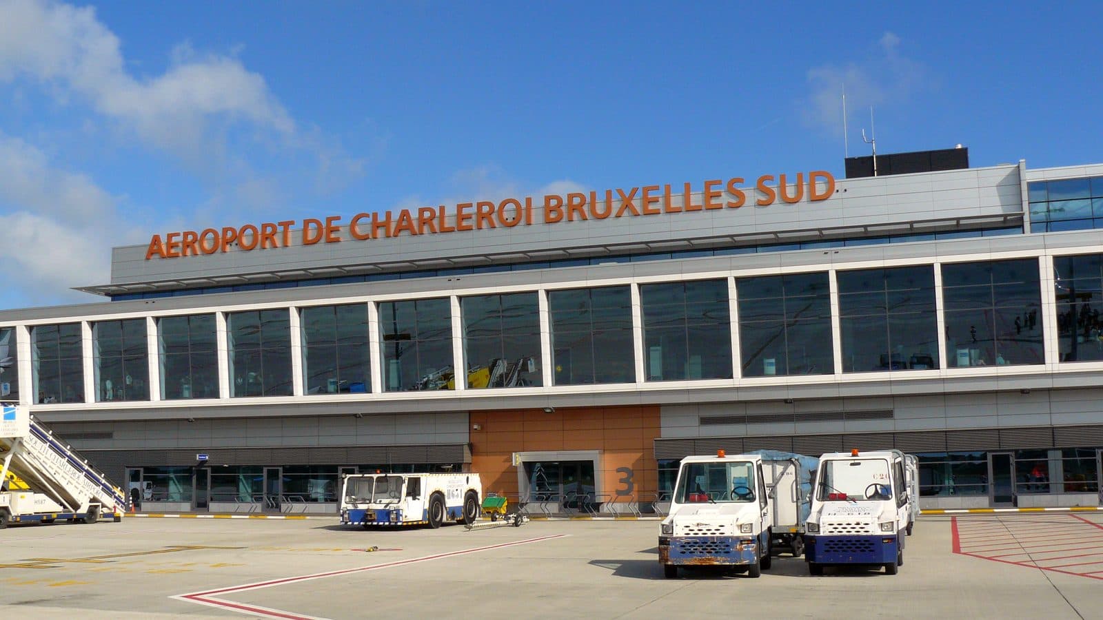 Brussels South Charleroi Airport terminal seen from the apron, with ground vehicles
